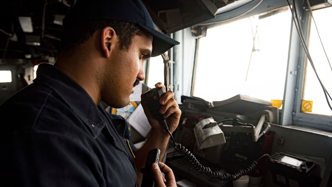 U.S. Navy bridge officer communicating by radio aboard the cruiser USS San Jacinto while transiting the Strait of Hormuz.