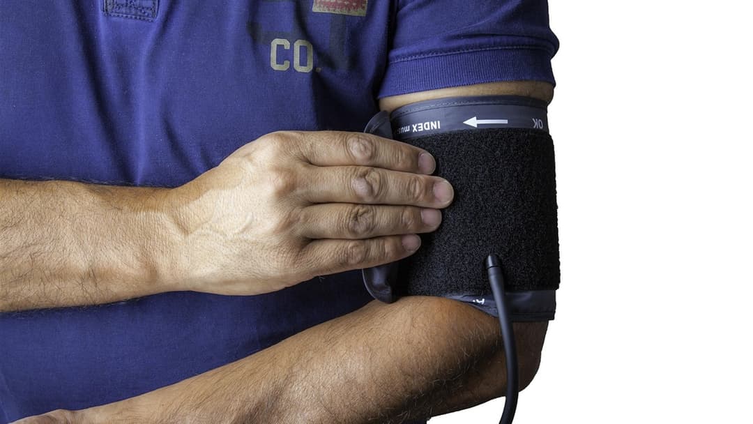 Digital blood pressure cuff and monitor placed on a table for cardiovascular screening.