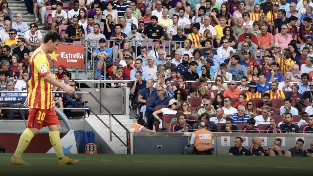 Lionel Messi smiling warmly and waving to supporters and family at Camp Nou.