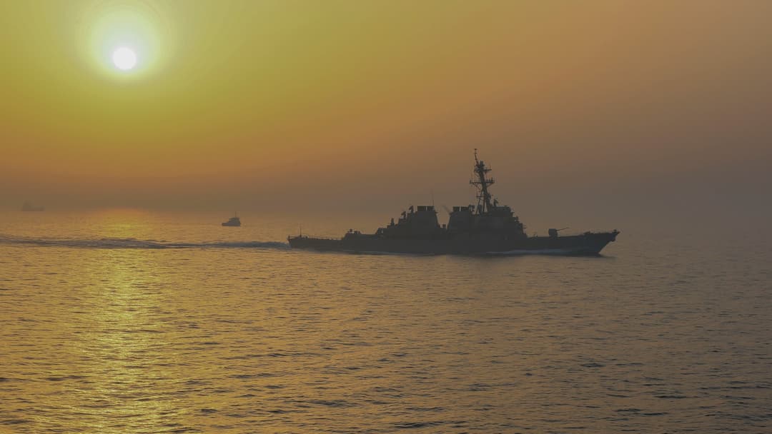 Guided-missile destroyer USS Stout transiting the Strait of Hormuz at dawn.