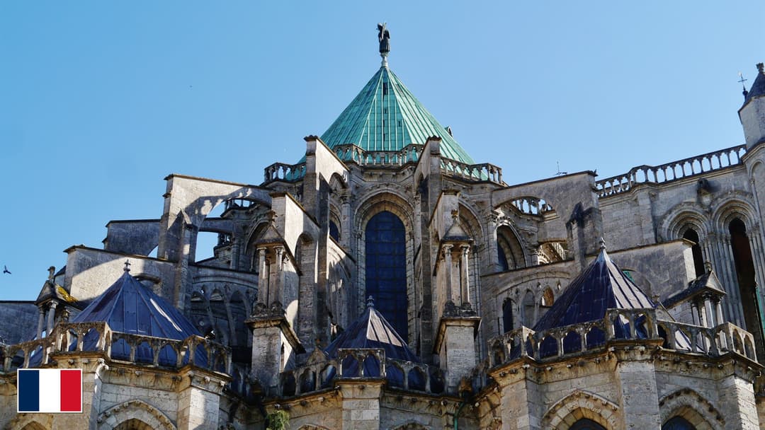 Chartres Cathedral High Gothic flying buttresses and green copper roof with flag of France in bottom-left corner