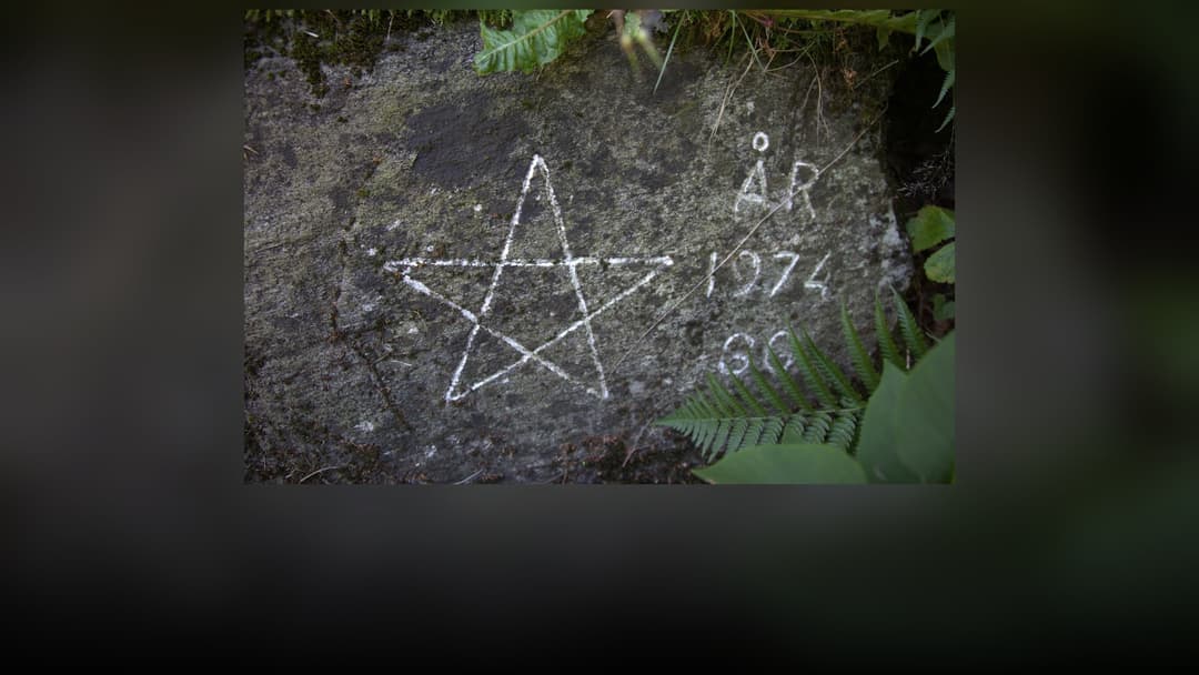 An ancient five-pointed pentagram star carved into weathered rock.