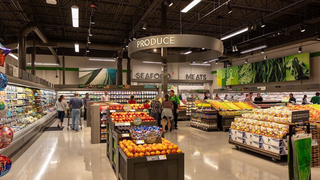 Supermarket produce section with fresh fruits and vegetables displayed.