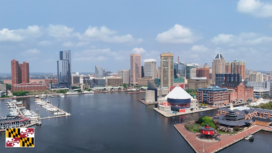 Baltimore Inner Harbor skyline in Maryland with the Maryland state flag in the bottom left corner