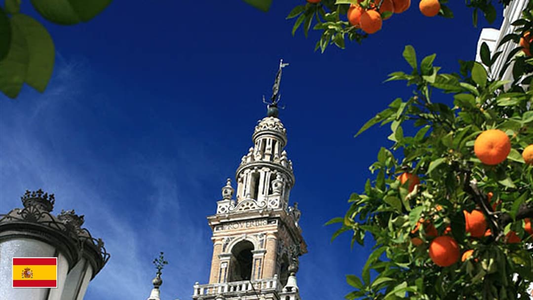 Seville Cathedral and La Giralda bell tower in Andalusia with flag of Spain in bottom-left corner
