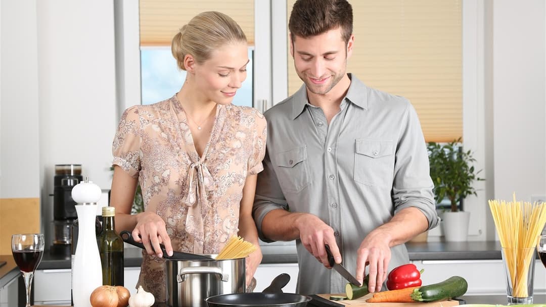 Couple cooking a healthy meal with fresh vegetables together in their kitchen