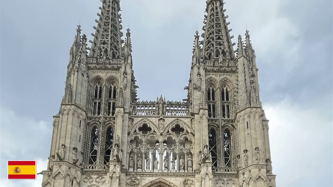 Burgos Cathedral openwork Gothic spires with flag of Spain in bottom-left corner
