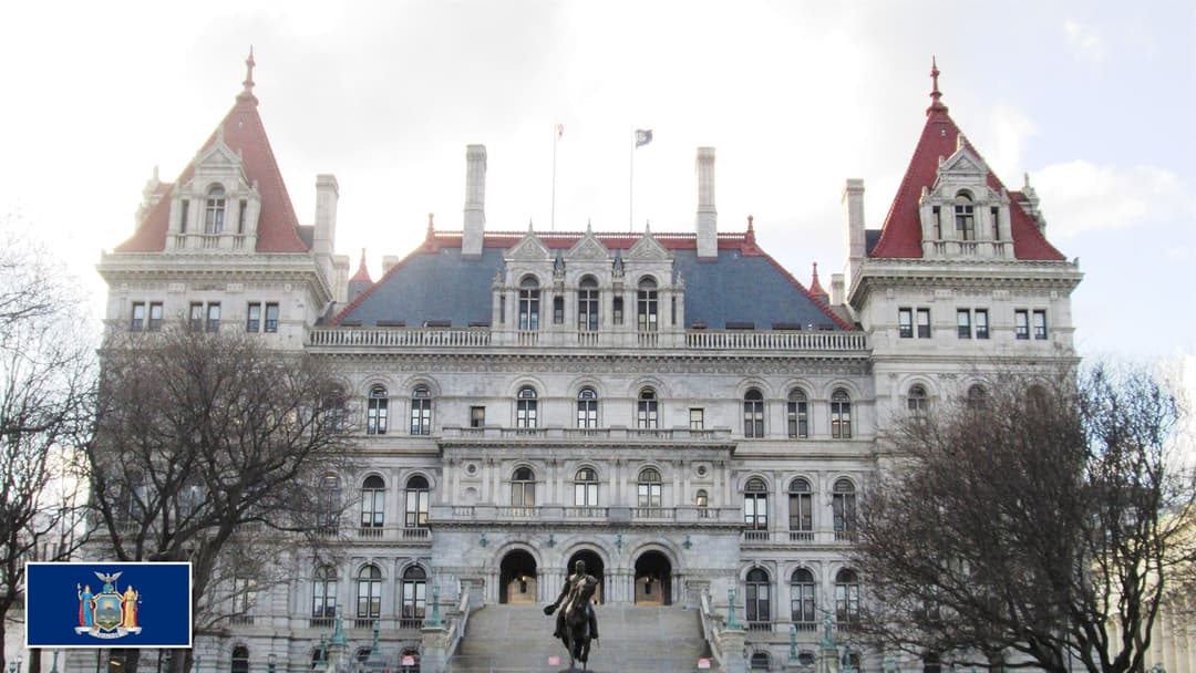New York State Capitol in Albany, New York with the New York state flag in the bottom left corner