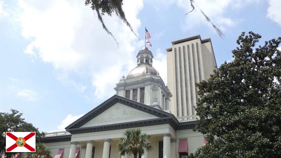 Florida Historic Capitol and State Capitol in Tallahassee, Florida with the Florida state flag in the bottom left corner