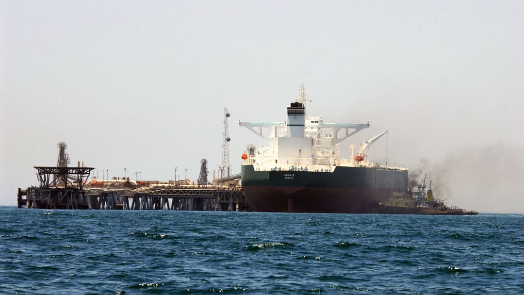 Commercial crude oil supertanker AbQaiq assisted by tugboats at an offshore Persian Gulf terminal.