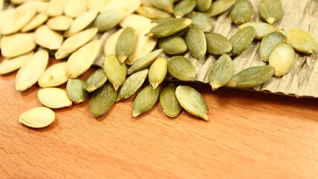 Close-up of raw whole pumpkin seeds rich in zinc and plant sterols.