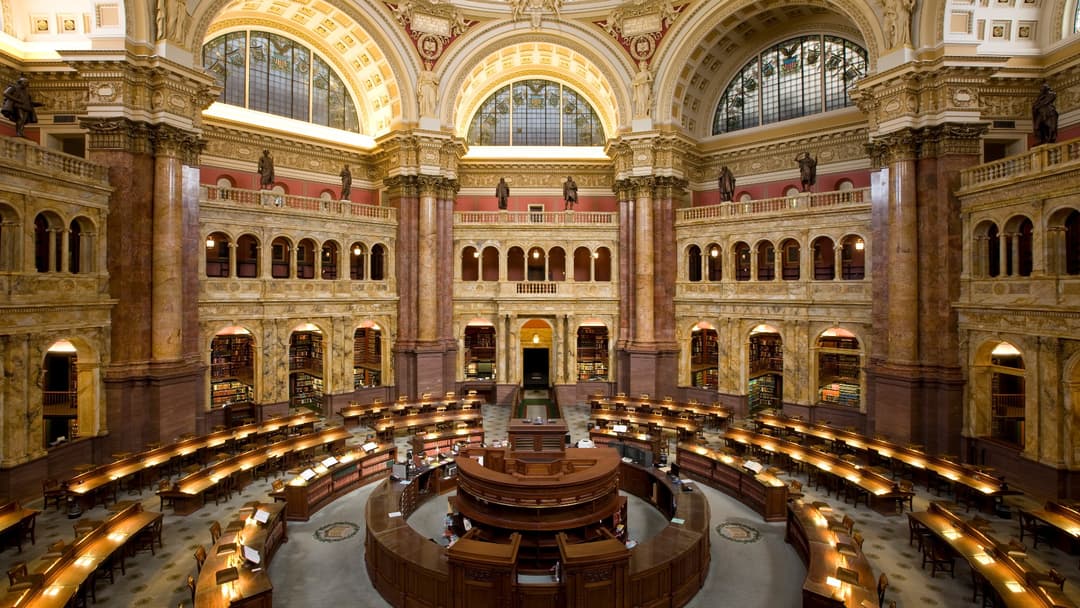 The historic main reading room at the Library of Congress lined with literary reference materials.