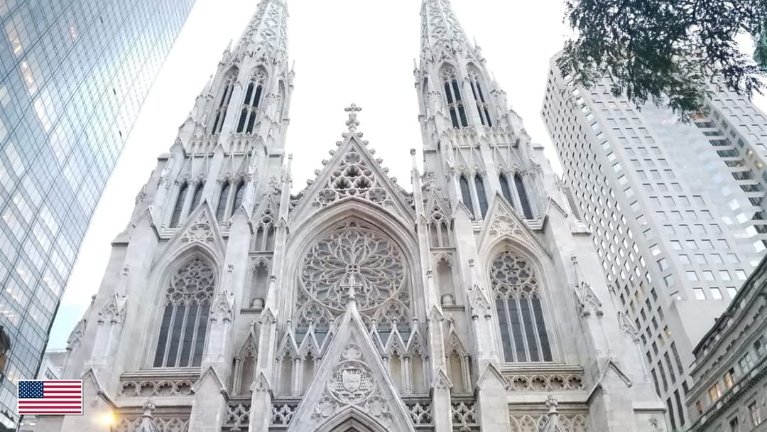 St. Patrick's Cathedral marble facade on Fifth Avenue in Manhattan with US flag in bottom-left corner
