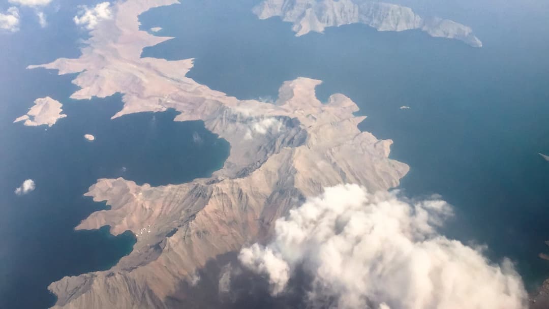 Aerial view of the rugged fjords and inlets of Oman's Musandam Peninsula jutting into the Strait of Hormuz.