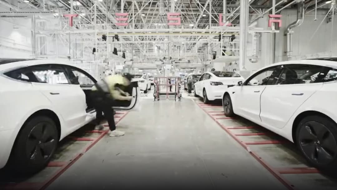 Automated robotic assembly line inside Tesla Gigafactory Shanghai producing electric vehicles.