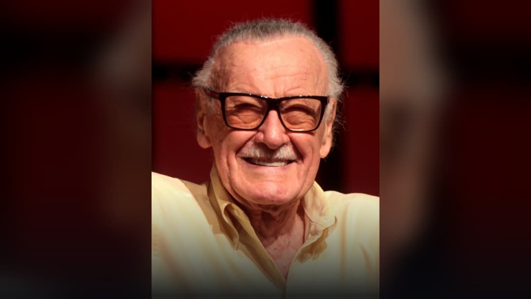 Marvel Comics co-creator Stan Lee smiling in signature tinted glasses at San Diego Comic-Con.