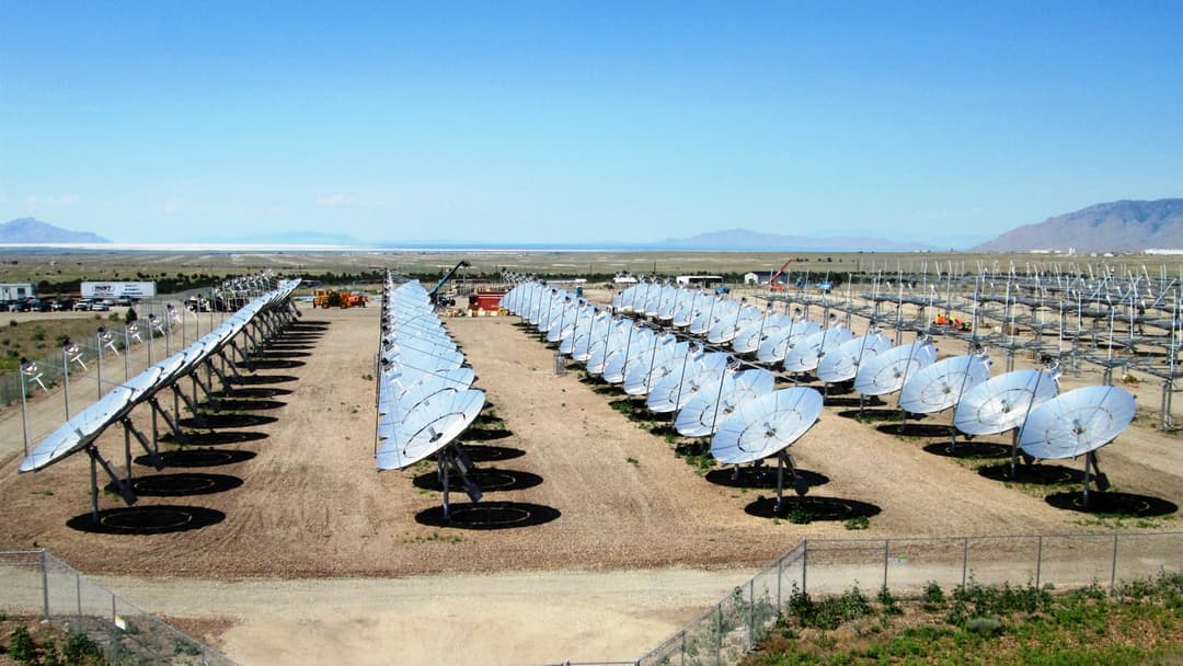 Rows of solar concentrator dishes at a utility-scale renewable energy facility