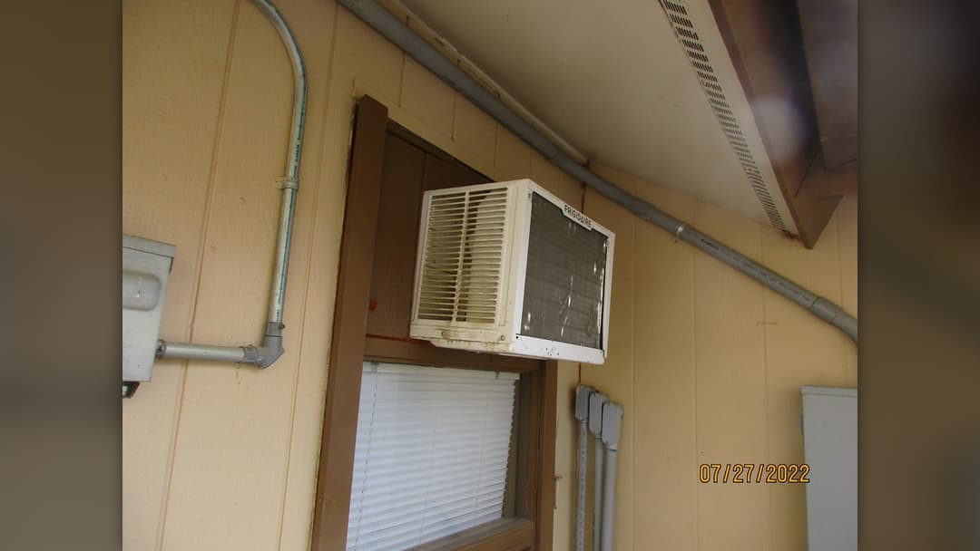 Exterior window air conditioner unit installed in a residential sash window