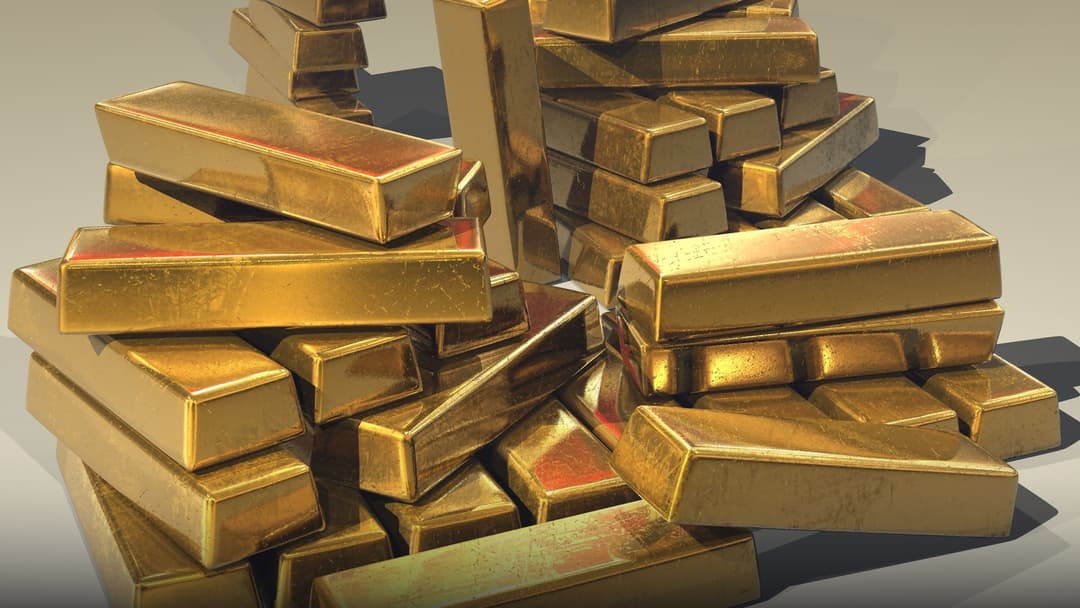 A massive pyramid stack of glistening 400-ounce gold bullion bars.