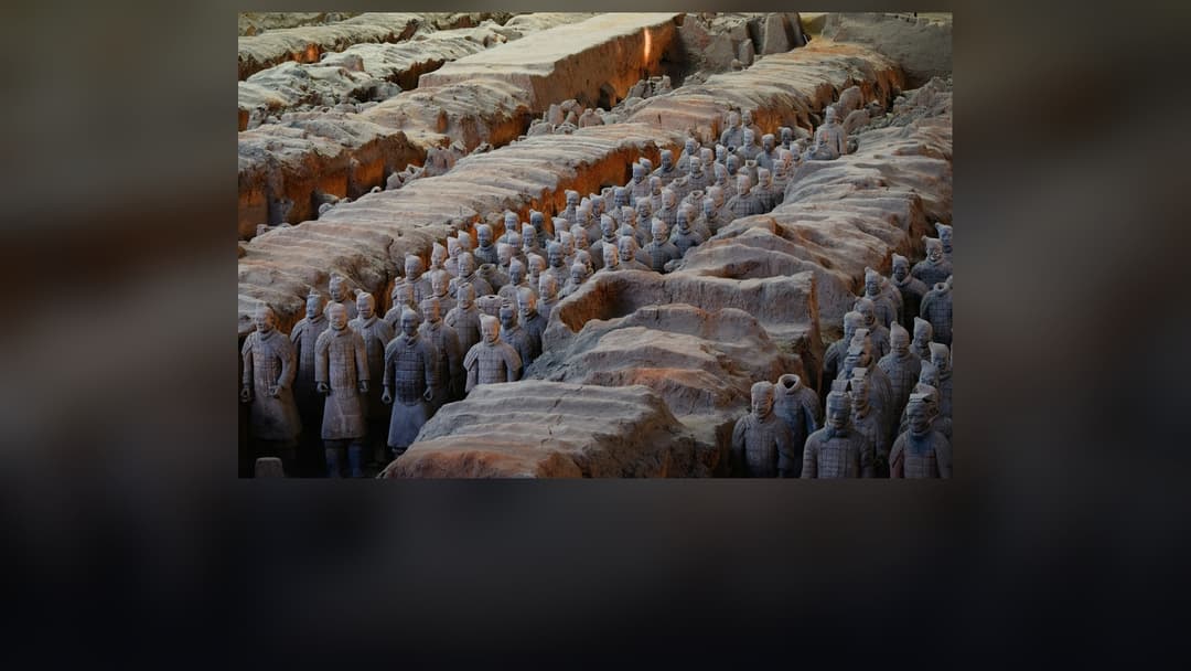 Ranks of life-sized terracotta soldiers standing in battle formation in Pit 1 in Xi'an.