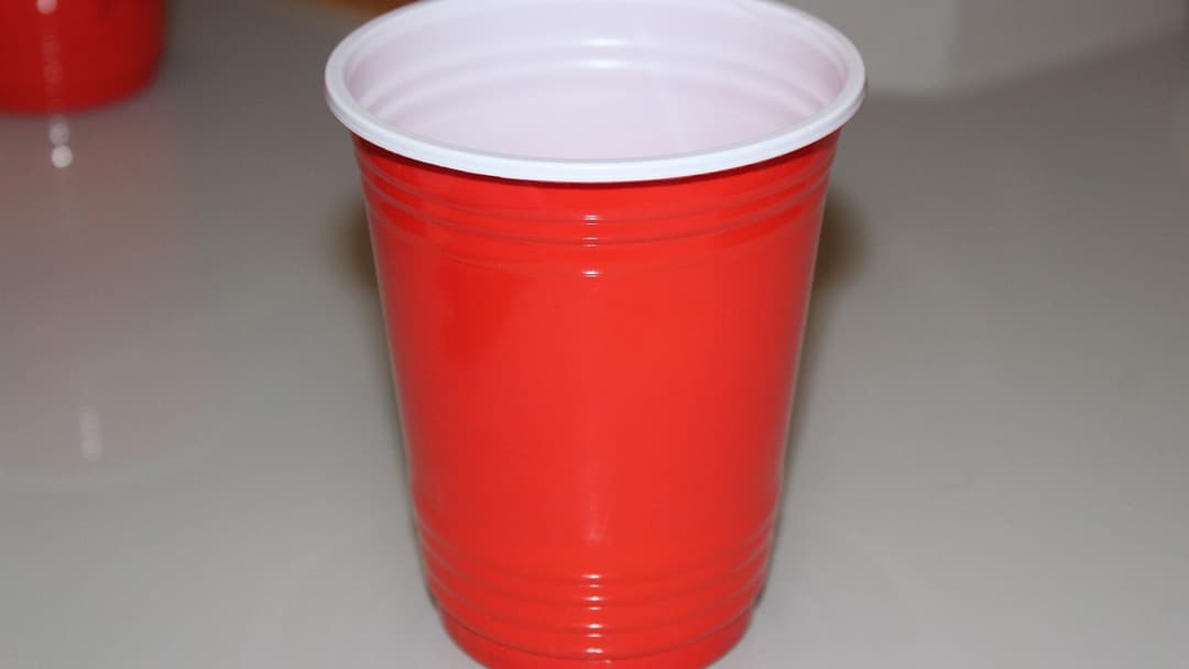 Stack of classic disposable red plastic party cups on a table
