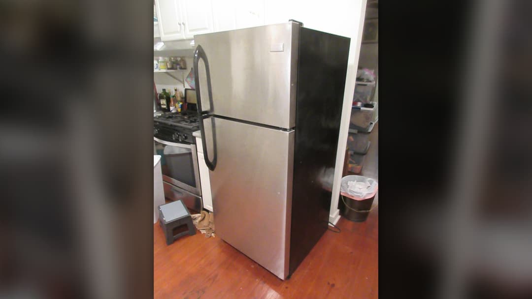 Stainless steel residential refrigerator in a kitchen setting