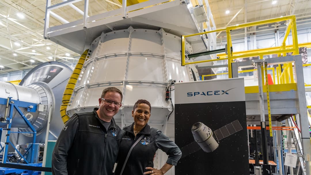 Inspiration4 commercial astronauts Sian Proctor and Chris Sembroski at NASA Johnson Space Center beside a SpaceX display