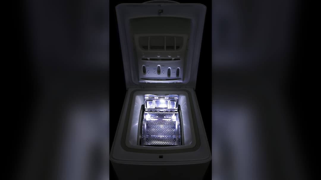Open top-loading washing machine showing the central agitator pole