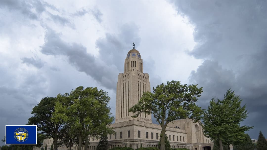Nebraska State Capitol in Lincoln, Nebraska with the Nebraska state flag in the bottom left corner
