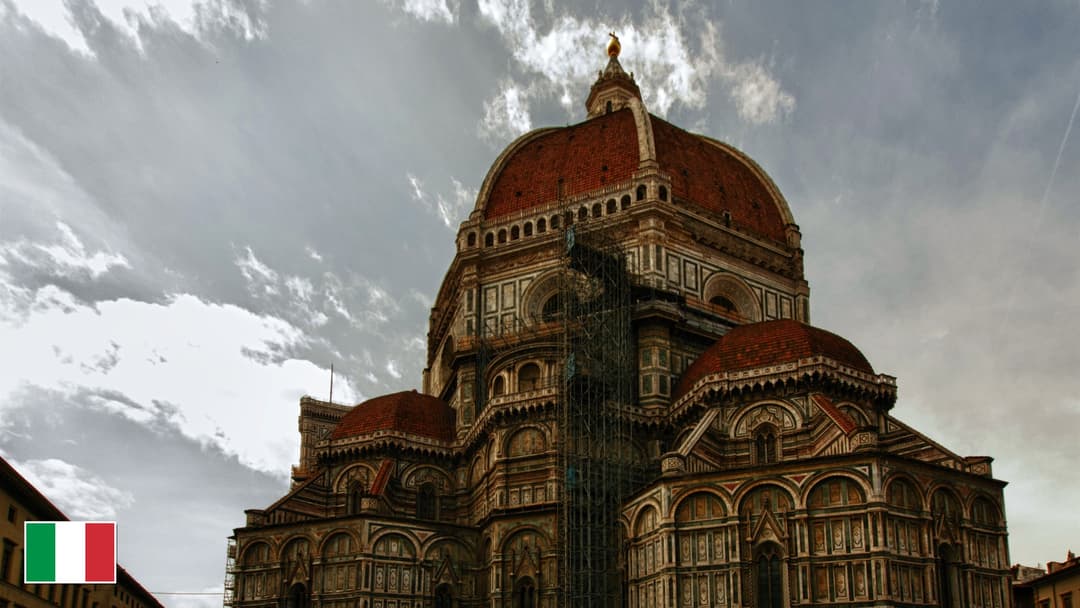 Florence Cathedral terracotta dome by Brunelleschi and Giotto's campanile with flag of Italy in bottom-left corner