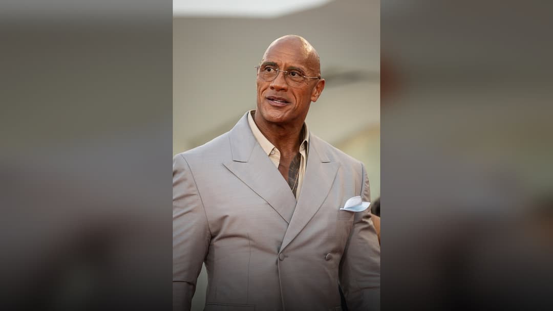 Dwayne Johnson posing at a major Hollywood premiere.