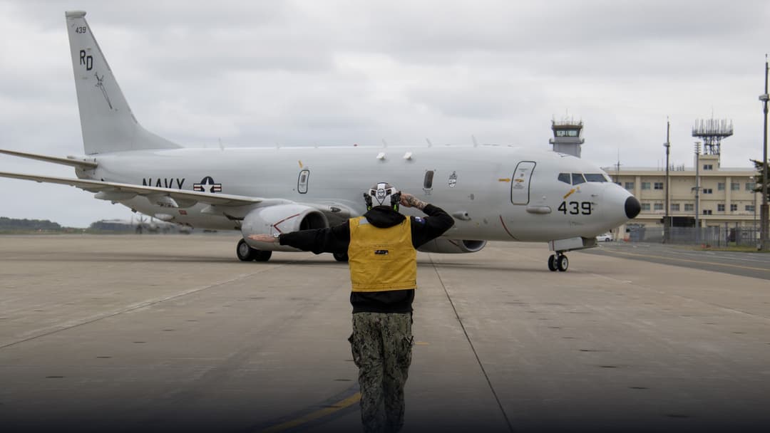 U.S. Navy P-8A Poseidon maritime patrol aircraft flying over ocean waters.