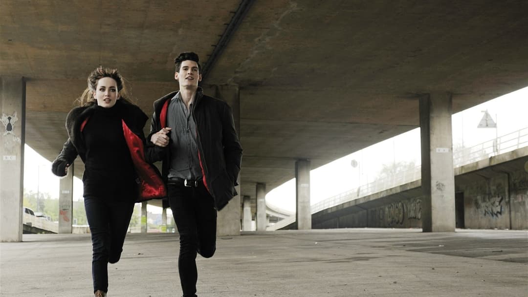 Active couple running side by side in matching dark jackets and sharing fitness habits