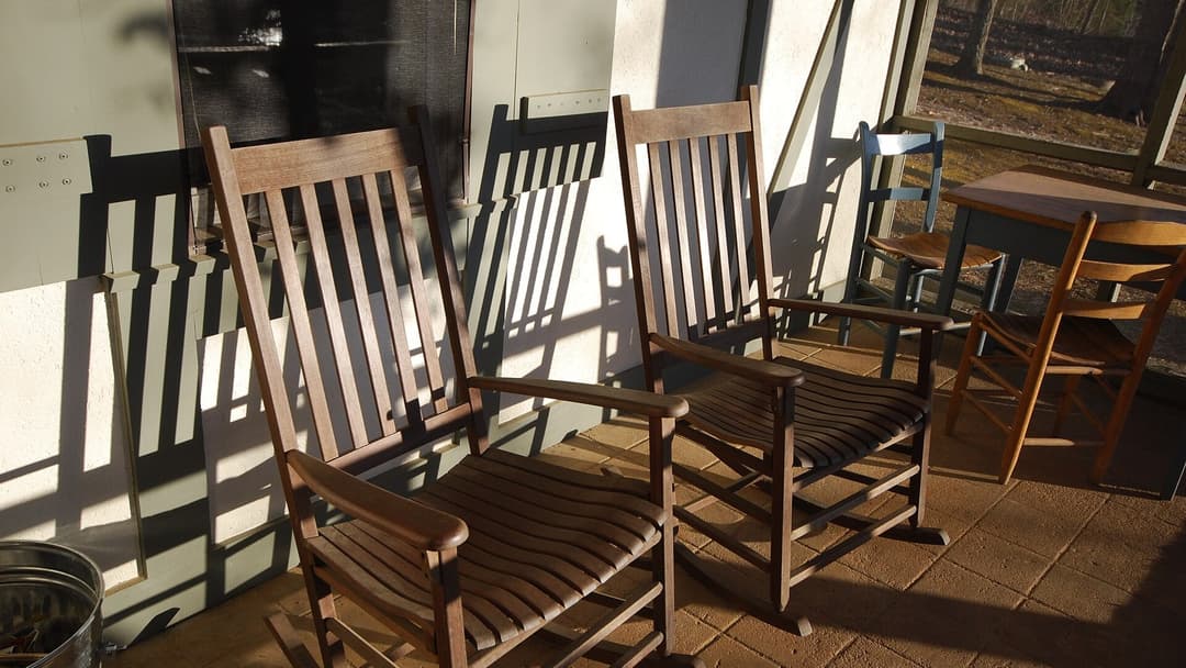 Screened-in porch with mesh netting and outdoor rocking chairs