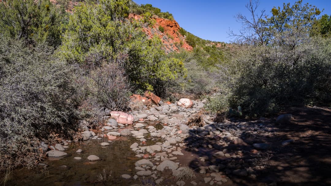 Woods Canyon in Sedona Arizona with dramatic red rock formations dusted in fresh winter snow under clear skies.