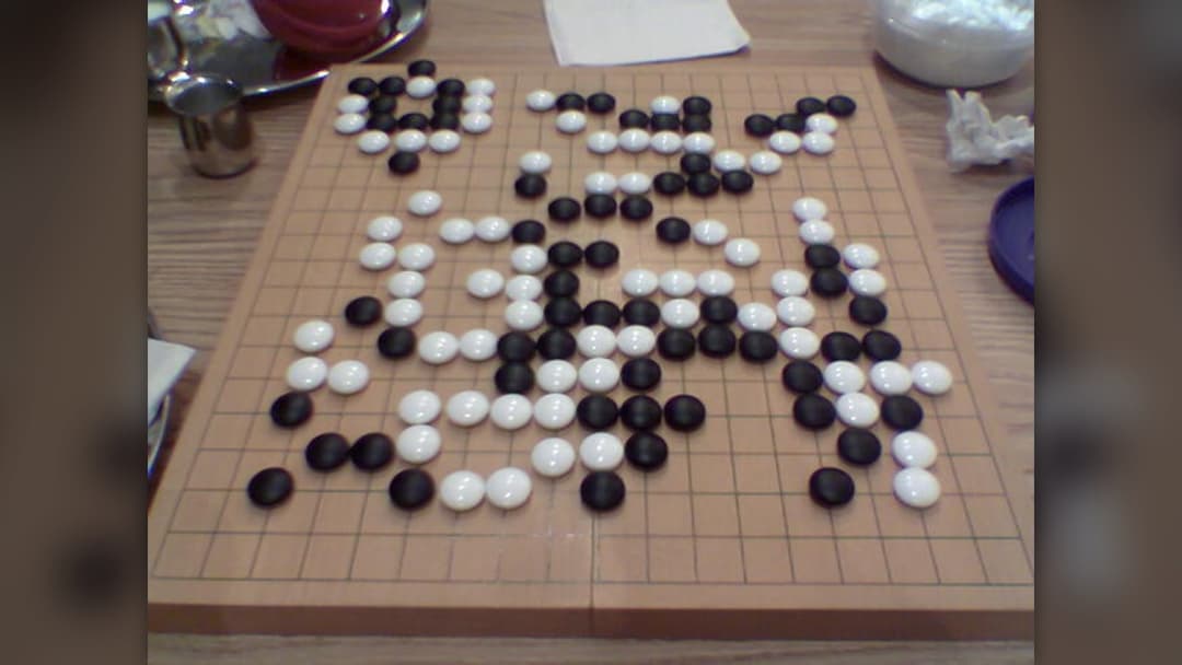 Traditional Go board with black and white stones positioned in an endgame formation
