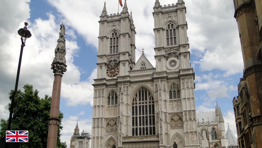 Westminster Abbey twin Gothic west towers in London with UK flag in bottom-left corner