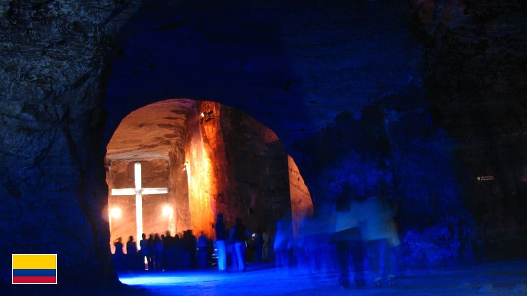 Underground Salt Cathedral of Zipaquira illuminated cross with flag of Colombia in bottom-left corner