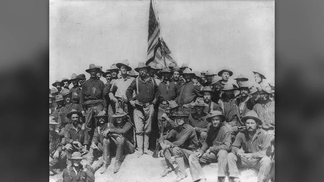 1898 photograph of Colonel Theodore Roosevelt and the Rough Riders standing atop San Juan Hill in Cuba.