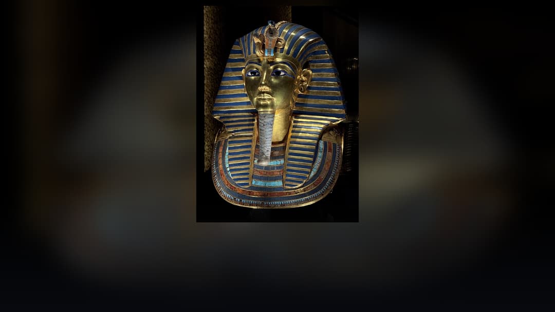 Golden funerary mask of Pharaoh Tutankhamun with lapis lazuli eyes and striped headdress.