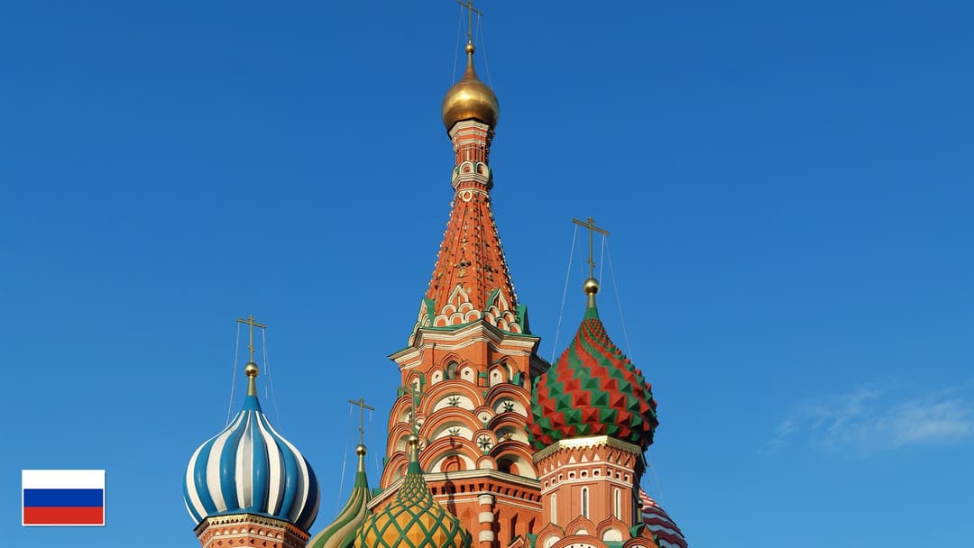 St. Basil's Cathedral colorful onion domes on Red Square in Moscow with flag of Russia in bottom-left corner