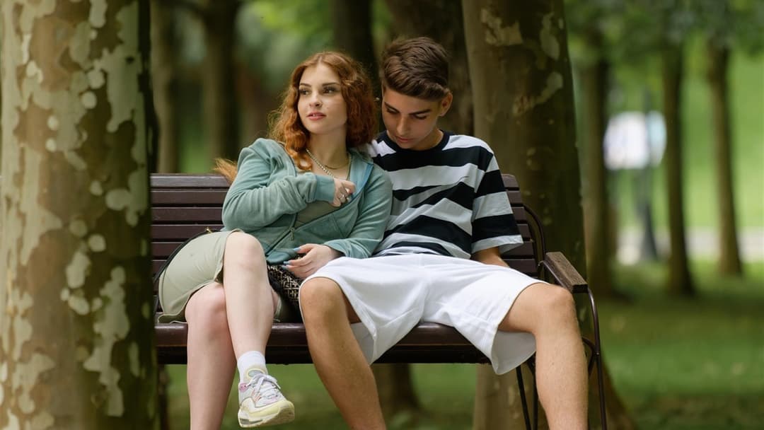 Young couple sitting side by side on a park bench showing similar core facial structure and bone geometry