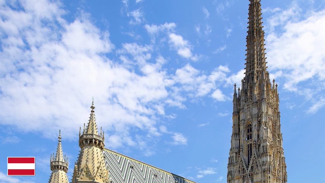 St. Stephen's Cathedral glazed tile roof and Gothic spire in Vienna with flag of Austria in bottom-left corner
