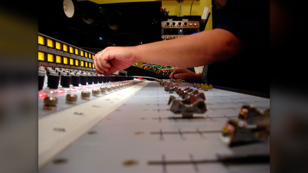 Audio engineer mixing on analog Neve console in recording studio
