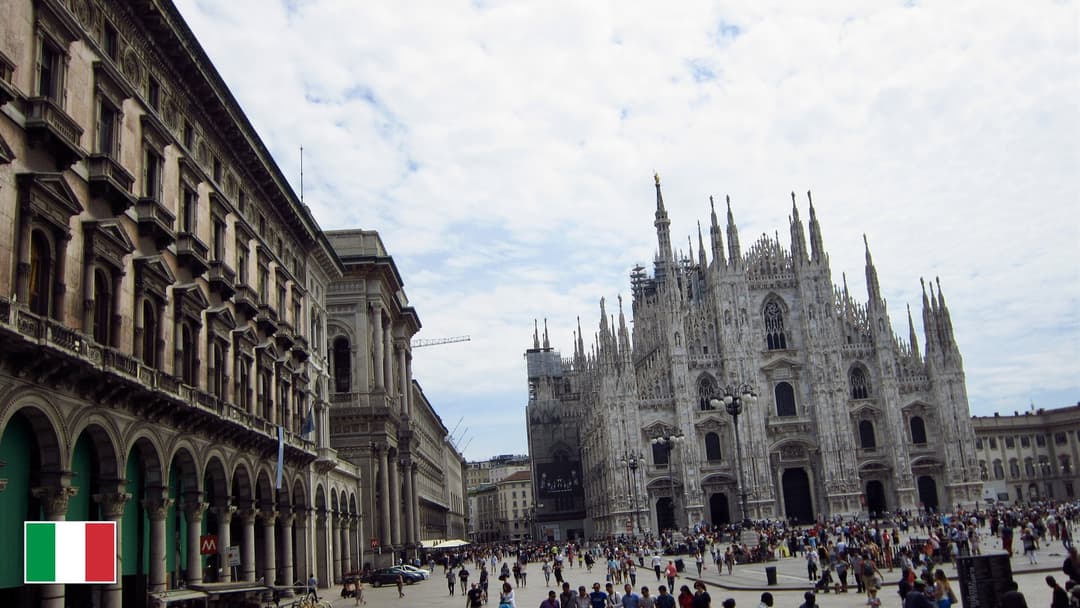 Duomo di Milano marble facade and spires in Milan with flag of Italy in bottom-left corner