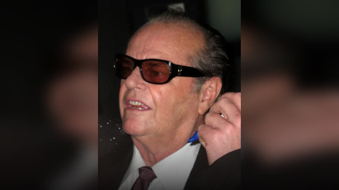Jack Nicholson smiling with sunglasses at an event.