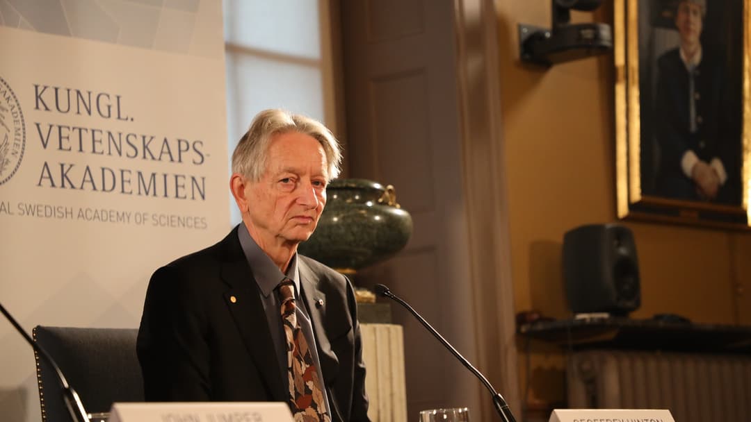 Close-up portrait of 2024 Nobel laureate Geoffrey Hinton looking contemplative against a dark studio background.