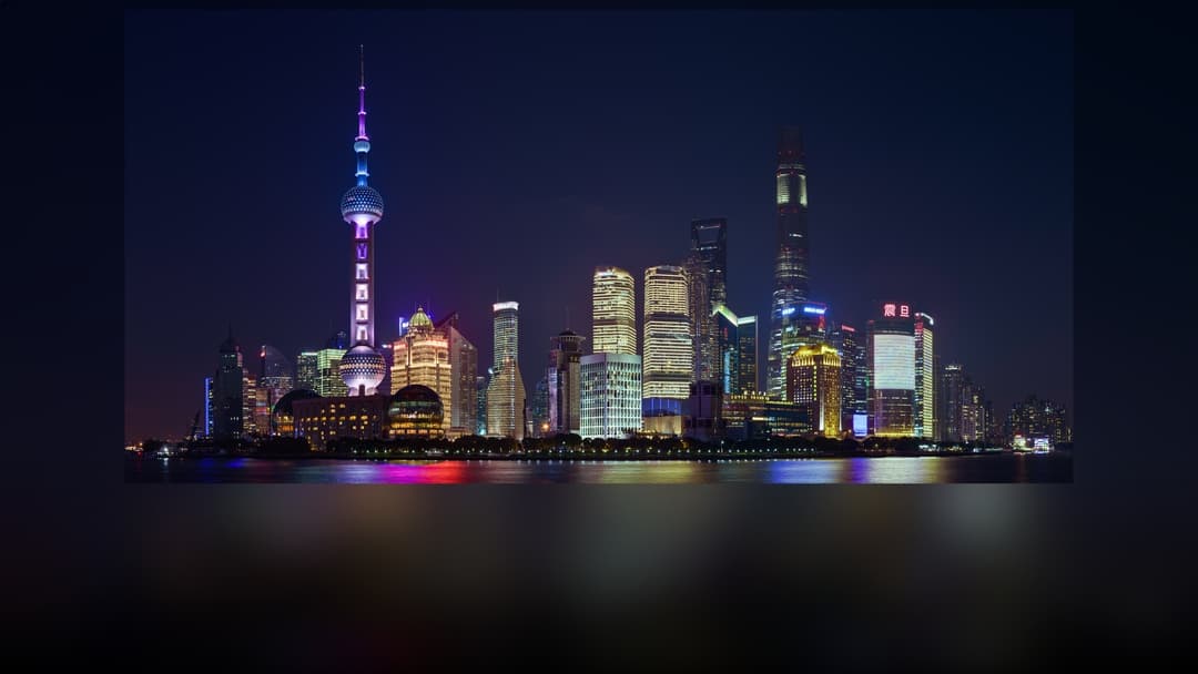 The futuristic Pudong skyline in Shanghai, China illuminated at night.