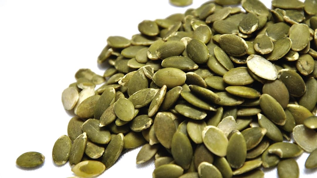 Macro photograph of shelled green pumpkin seed pepitas packed with magnesium.
