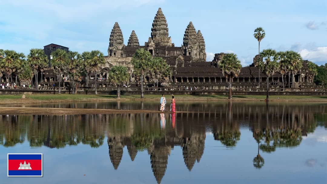 Angkor Wat temple reflected in the lotus pond in Siem Reap, Cambodia with the Cambodian flag in the bottom left corner